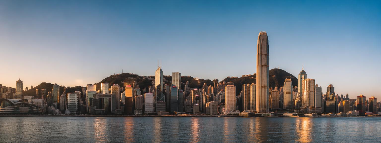 Hong Kong skyline across Victoria Harbour at golden hour